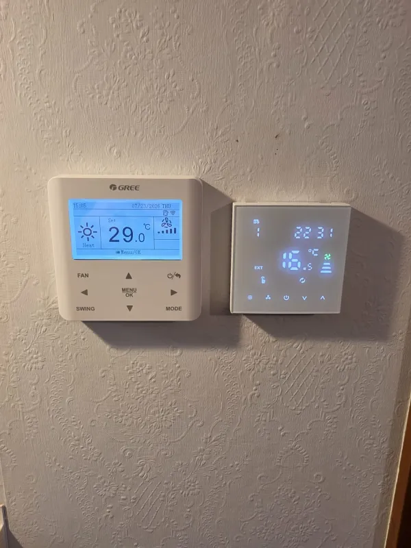 Two wall controllers side by side, one showing 29 degrees