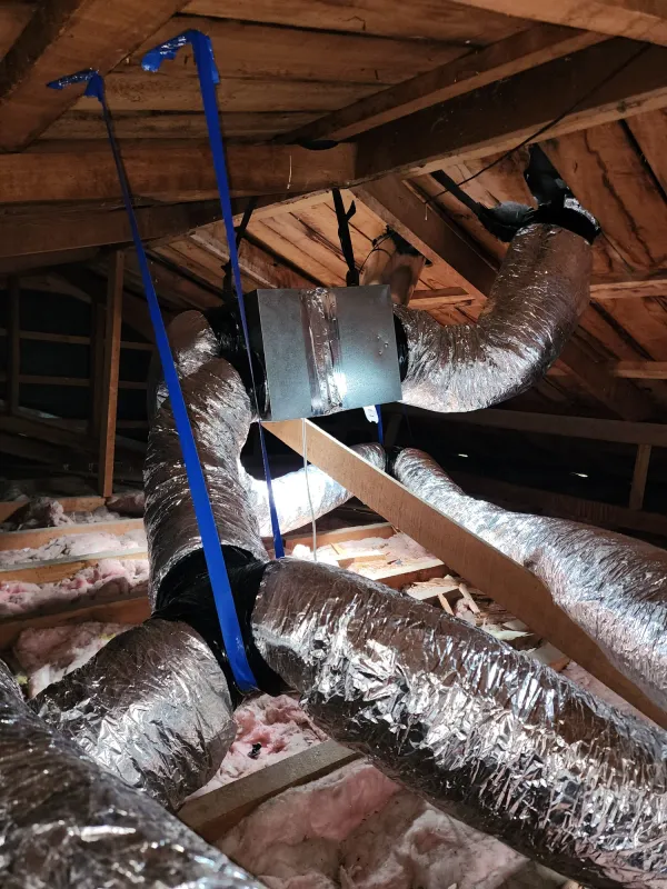 Air handling unit and branching insulated ducts strapped in a roof space