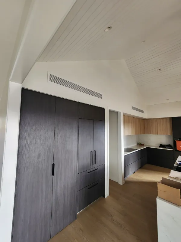 Wide return air grille set into a hallway ceiling