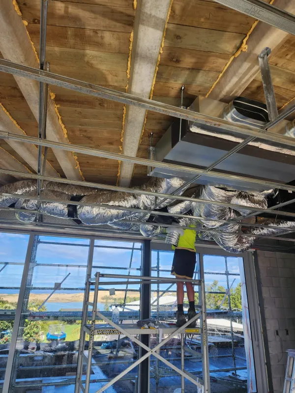 Ducted indoor unit with insulated ducting branching into the roof space