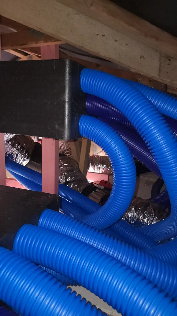 Wide view of a ducted heat pump indoor unit suspended in a roof space
