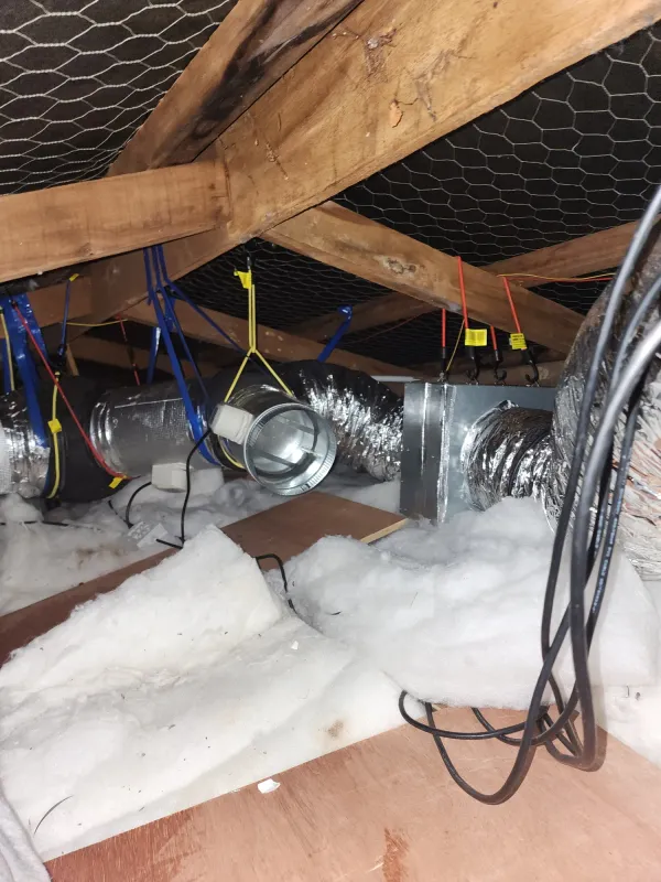 Ducting, motorised zone dampers and wiring laid across roof space insulation