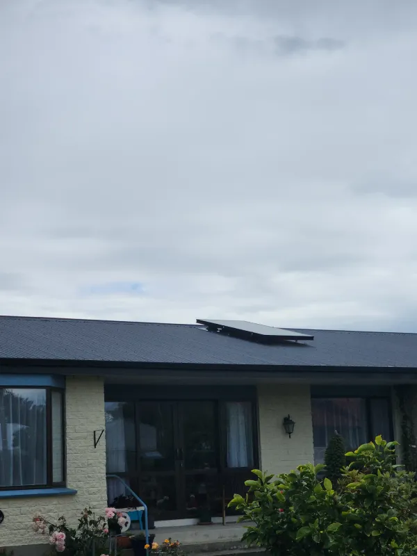 Brick and weatherboard home with a solar air panel on its charcoal roof