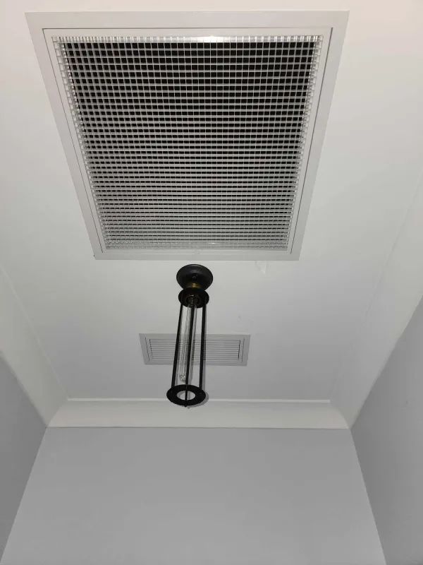 Ceiling manhole for roof space access beside a ducted outlet