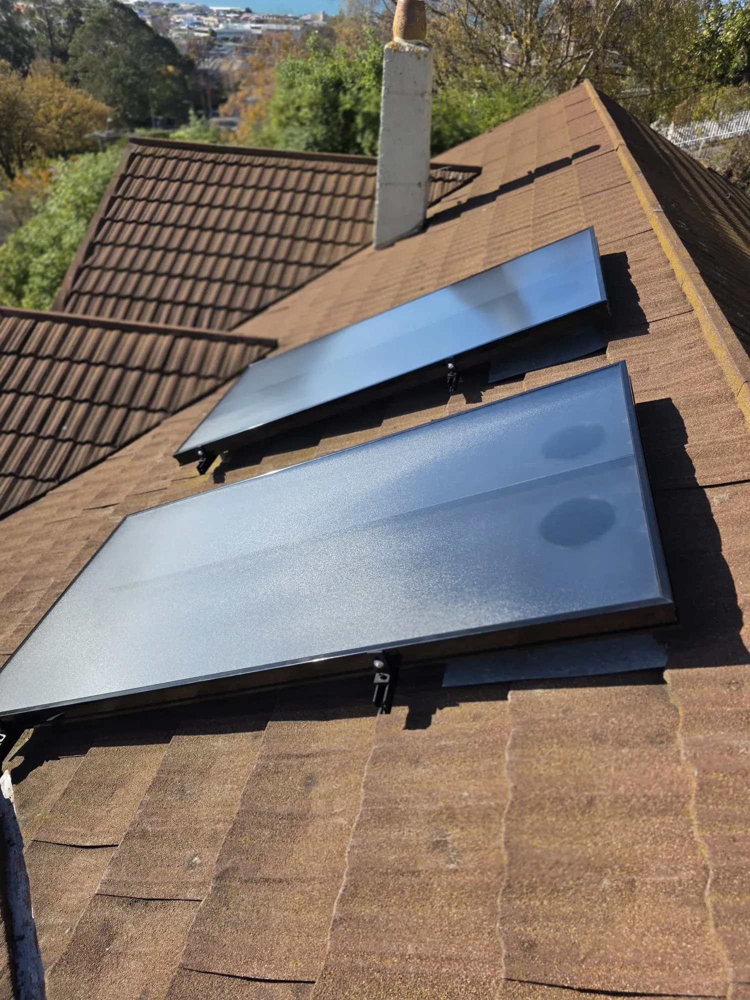 Two solar air panels on a tiled roof