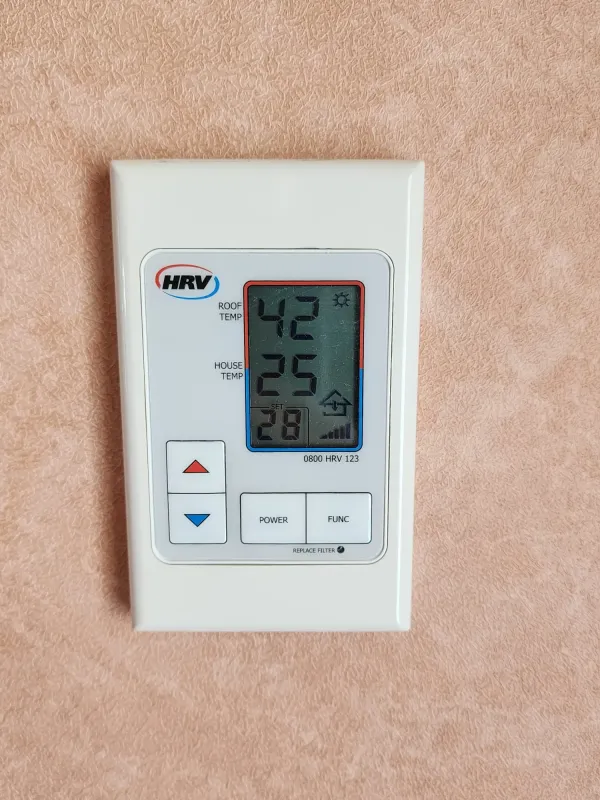 Digital wall controller showing roof and house temperature readings