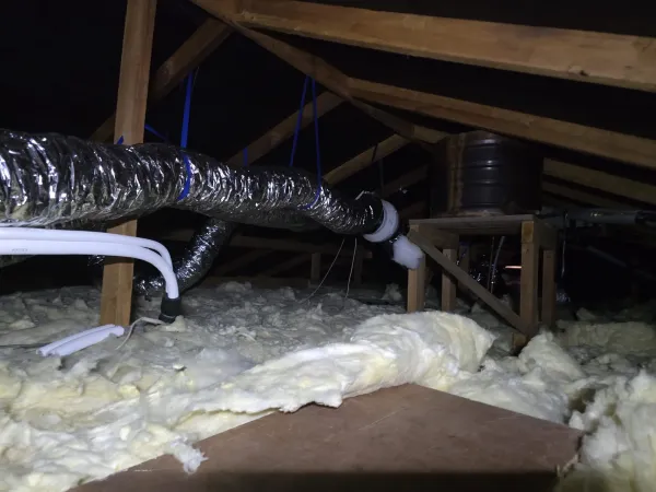 Solar air collector housing connected to insulated ducting in a roof space
