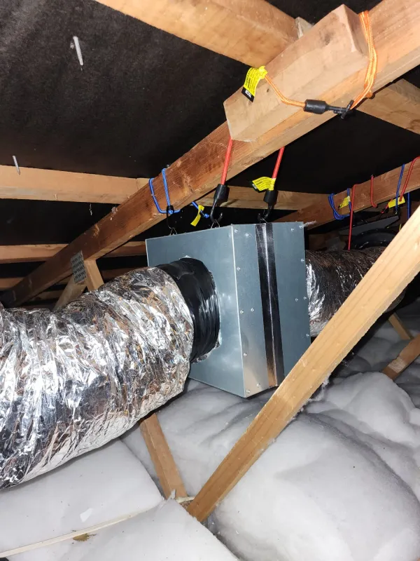 Insulated duct run secured across roof trusses